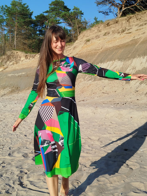 Woman modeling a green abstract midi dress with long sleeves and artistic abstract print, elegant feminine silhouette, modern statement midi dress for women