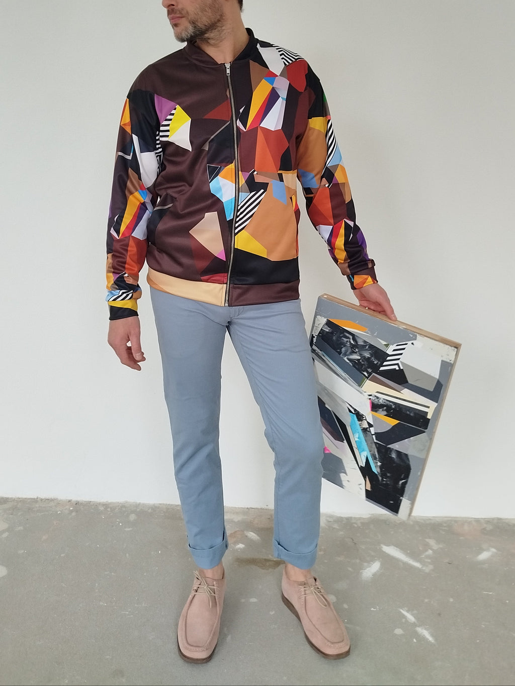 Man wearing a colorful brown geometric-patterned bomber jacket, modern artistic design, bold statement fashion, wearable art jacket for men, stylish streetwear outerwear
