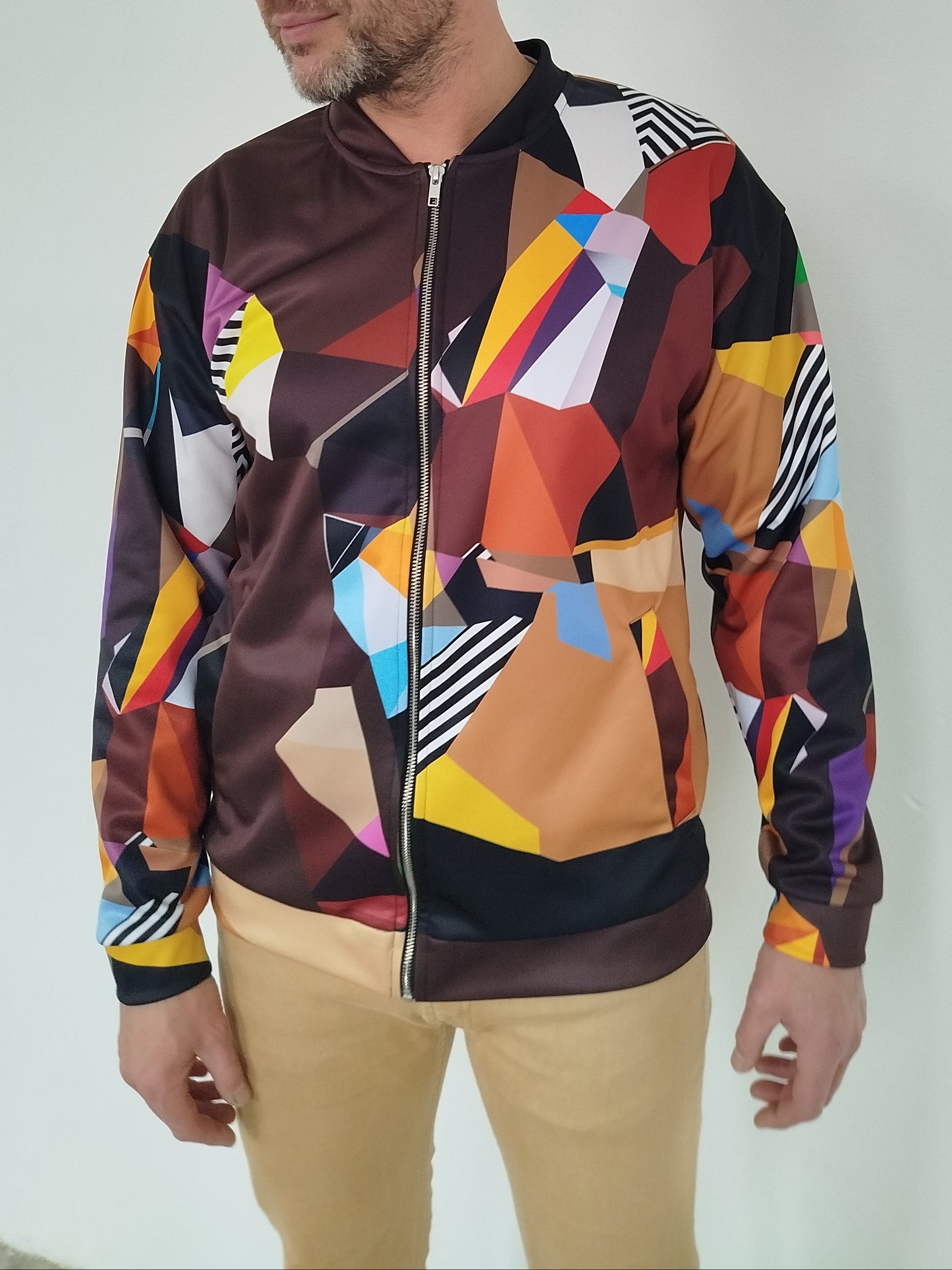 Side view of a man in a colorful brown geometric-patterned bomber jacket, bold artsy design for men