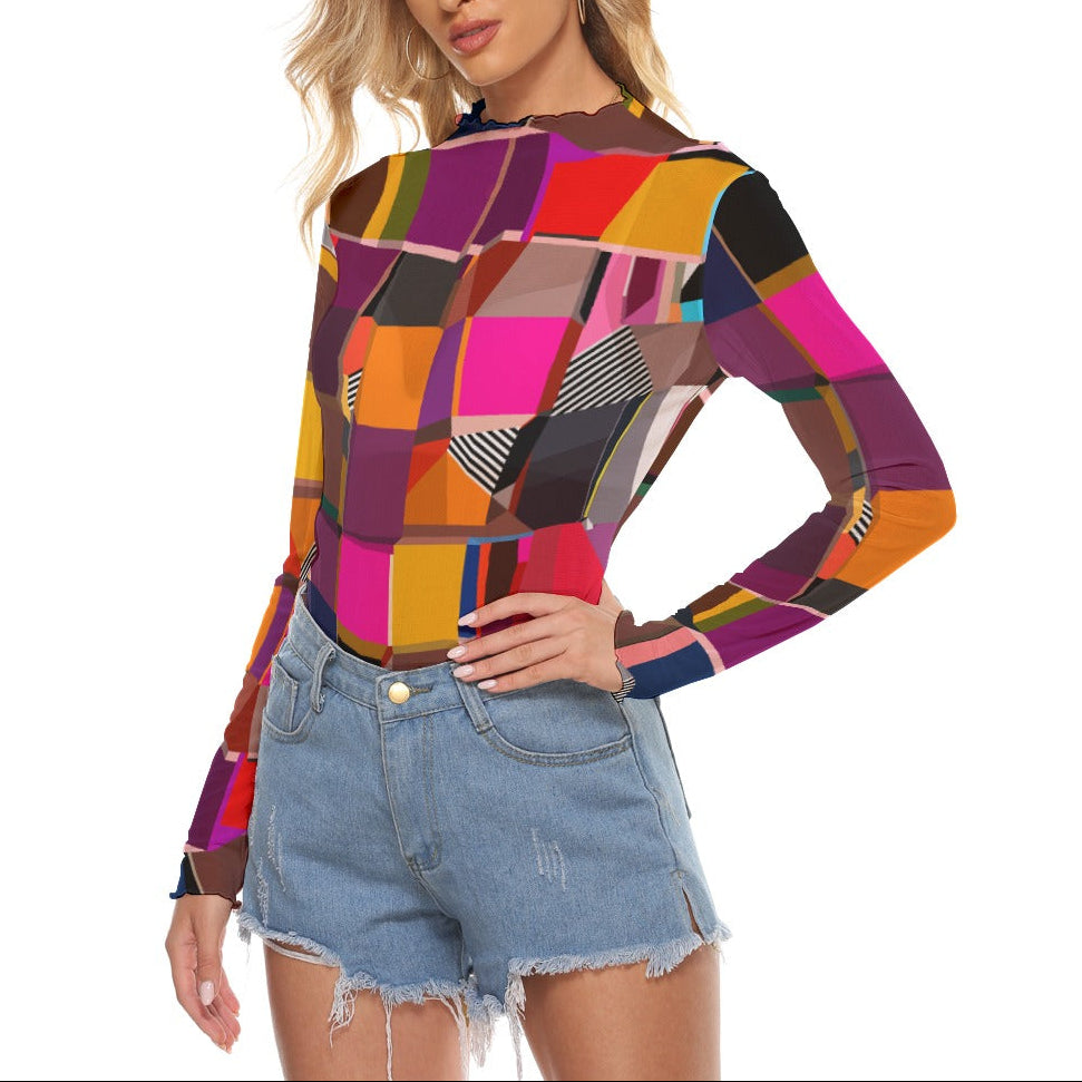 Woman wearing a colorful sheer mesh top and denim shorts on a white background