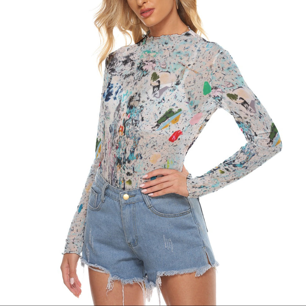 Woman wearing a colorful long-sleeve top and denim shorts on a white background