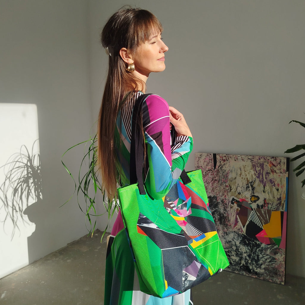 Woman holding a colorful bag in a room with plants and artwork.