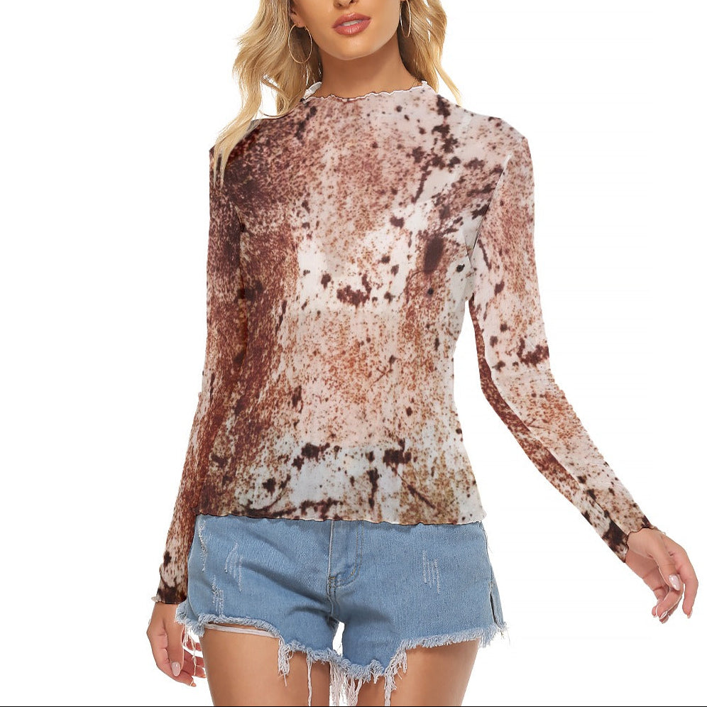 A woman modeling a long-sleeve mock neck top with a brown rustic pattern, paired with light blue denim shorts, against a plain white background.