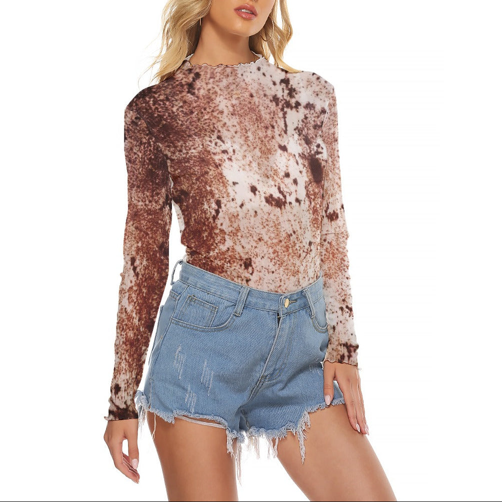 A woman modeling a long-sleeve crewneck top with a brown and beige tie-dye pattern, paired with light-wash denim shorts, against a plain white background.