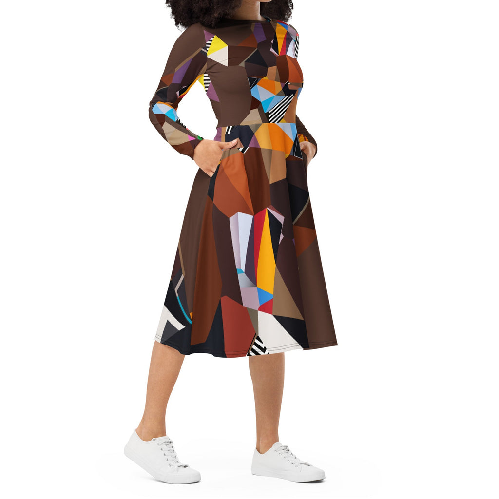 Lifestyle shot of a woman wearing a brown geometric artistic midi dress with long sleeves and pockets, modern wearable art fashion styled for everyday and special occasions