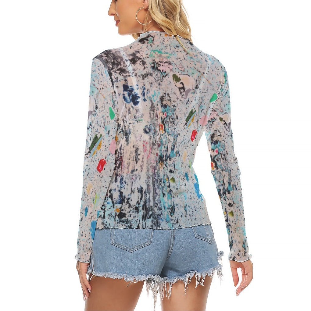 Woman wearing a colorful patterned jacket and denim shorts on a white background
