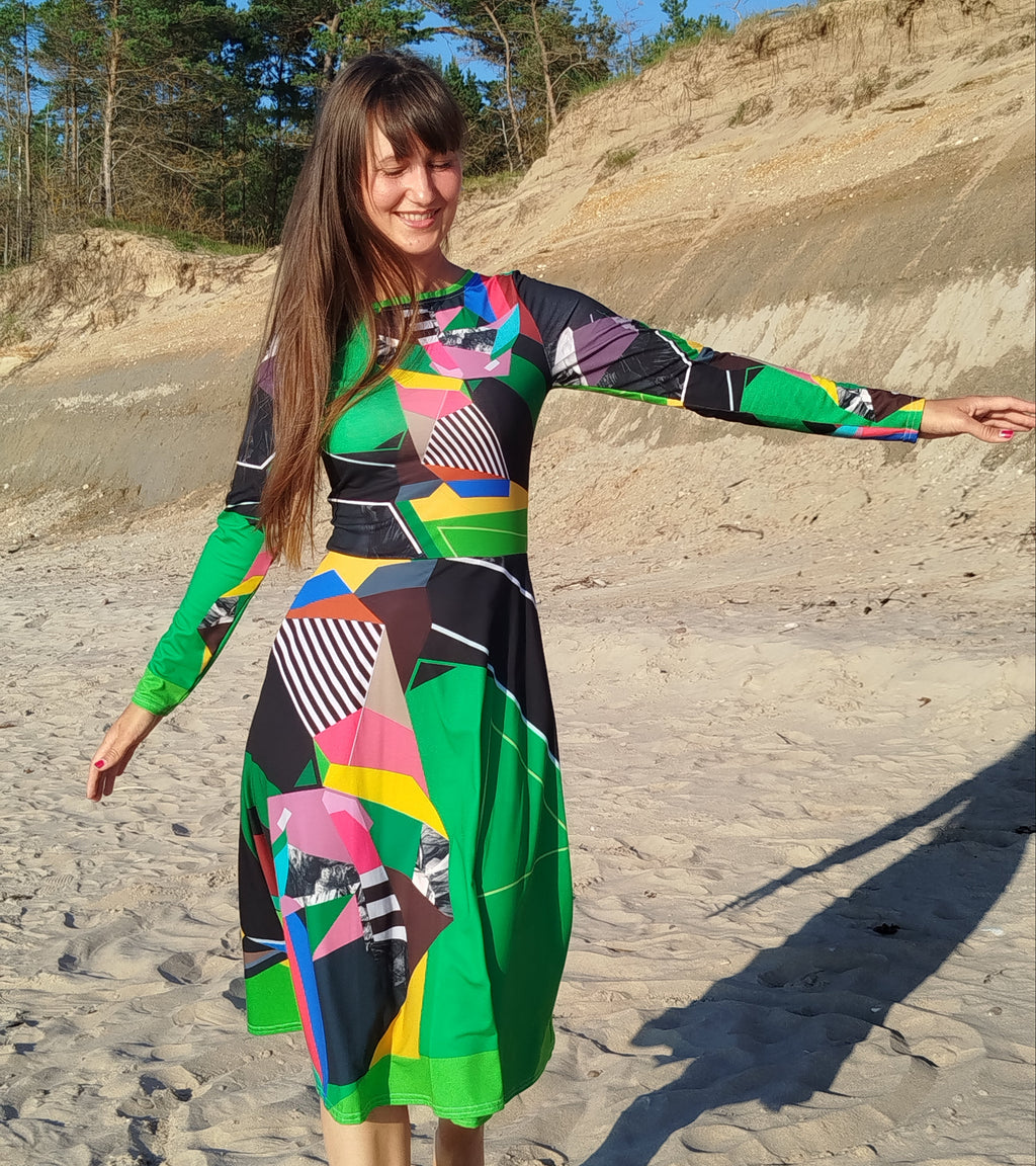 Woman modeling a green abstract midi dress with long sleeves and artistic abstract print, elegant feminine silhouette, modern statement midi dress for women