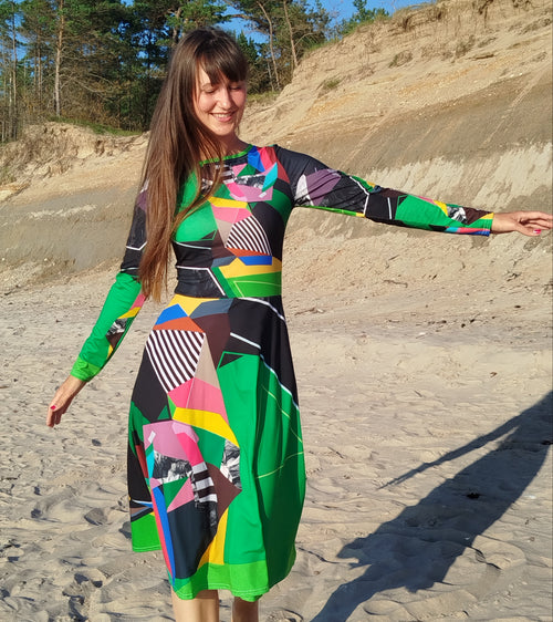 Woman modeling a green abstract midi dress with long sleeves and artistic abstract print, elegant feminine silhouette, modern statement midi dress for women